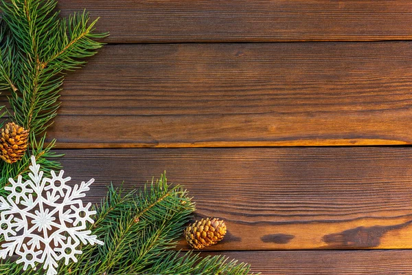 圣诞框架与冷杉树枝，圆锥，雪花和红色的礼物在黑暗的木制桌子上。带有文本空间的顶部视图 — 图库照片