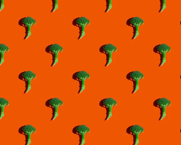 Grön broccoli på orange bakgrund mönster — Stockfoto