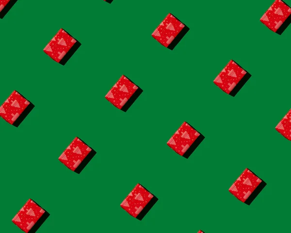 Röd gåva på grön bakgrund mönster — Stockfoto