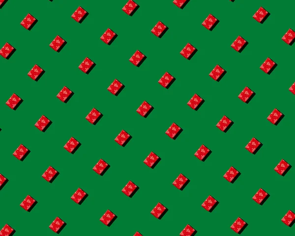 Röd gåva på grön bakgrund mönster — Stockfoto