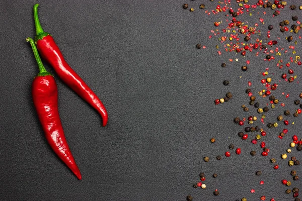 Red hot pepper chili na czarnym tle z przyprawami. Wolne miejsce — Zdjęcie stockowe