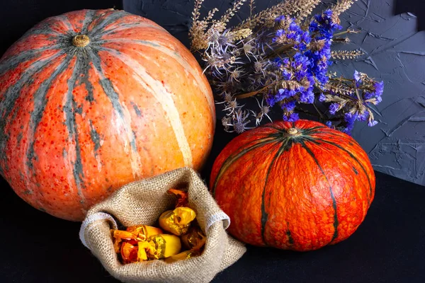 Abóbora com flores e doces em uma mesa de madeira. Halloween outono tema — Fotografia de Stock