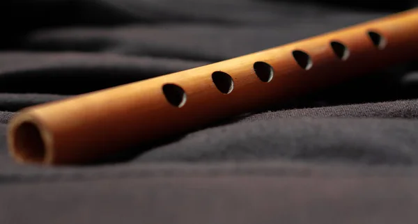 A musical instrument bamboo flute placed on a dark background