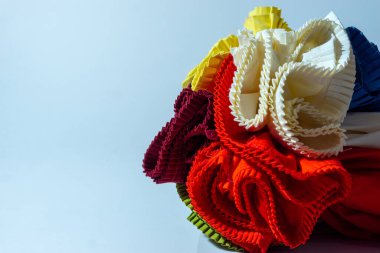 Beyaz arka plana renkli bir kumaş rulo yerleştirilmiş.