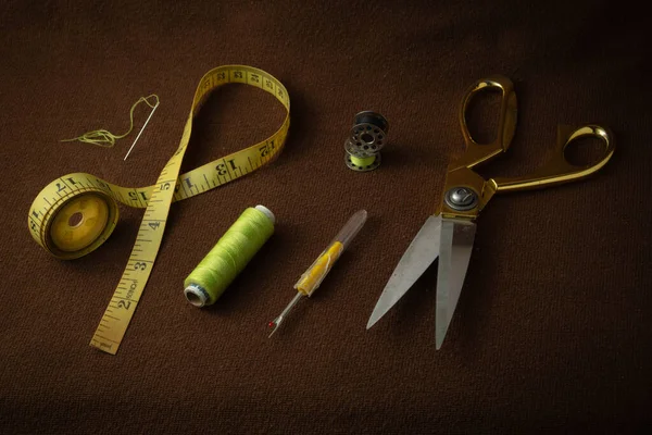 Kahverengi bir arka planda tutulan terzilik malzemeleri