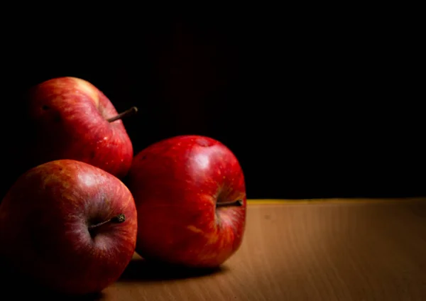 Äpfel Auf Einem Holztisch Vor Schwarzem Hintergrund Gestapelt — Stockfoto
