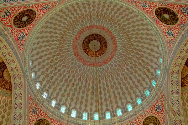 Красочные исламские узоры и орнаменты в сочетании с арабской каллиграфией Корана на куполе мечети Кокатепе в Анкаре. Исламское искусство, архитектура и стиль в интерьере мечети. 