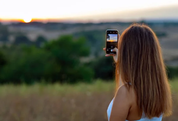 Gadis Muda Mengambil Foto Sunset Dengan Smartphone Nya — Stok Foto