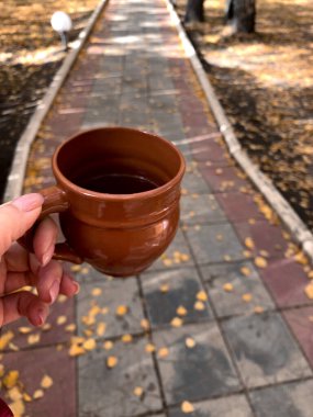 Elinde çay tutan kişi.