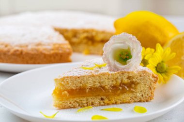 Çiçeklerle süslenmiş, limonlu bir dilim turta..