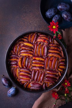 Erikli çikolatalı erik turtası ve geometrik erik süslemesi. Koyu arkaplan.