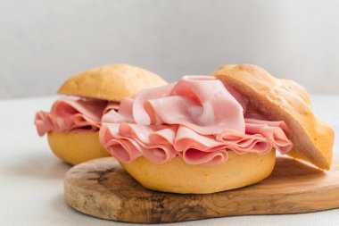 Mortadella ile sandviç. Bolonya 'dan dilimlenmiş mortadella. Büyük bir İtalyan sosisi ya da etli öğle yemeği. Tipycal İtalyan ekmeği, La Rosetta. Boşluğu kopyala.