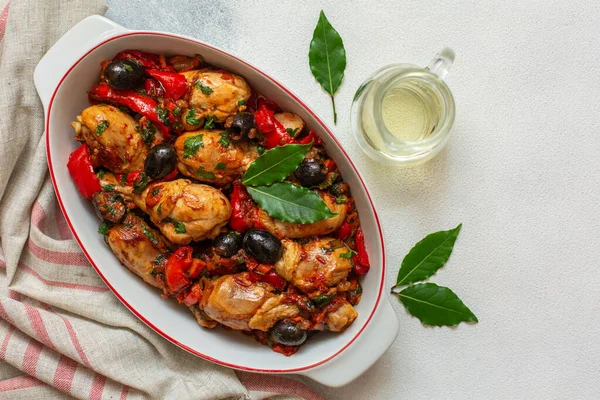 Tavuk cacciatore - domatesli avcı tarzı İtalyan tavuğu, siyah zeytin ve kırmızı dolma biber. Beyaz arka plan. Boşluğu kopyala.