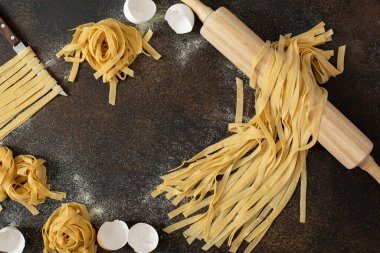 Çiğ ev yapımı tagliatelle, İtalyan yumurtalı makarnası ve siyah masa.