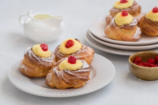 İtalyan pastası - zeppole di San Giuseppe - choux pastasından yapılmış kremalı pasta, krema ve kirazla doldurulmuş. Aziz Yusuf Günü 'nü kutlamak için yenir. Beyaz masa. Yatay resim.
