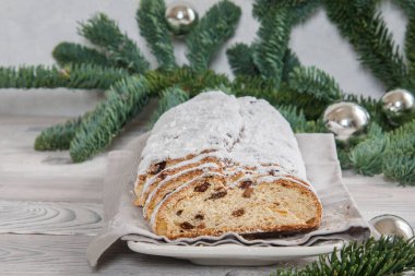 Ev yapımı Noel Stollen. Ceviz, baharat ve kuru üzümlerden oluşan toz şekerle kaplanmış bir Alman meyveli ekmek..