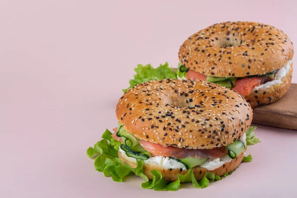 Bagel Con Salmone Affumicato Crema Formaggio Insalata Cetriolo Sfondo Rosa — Foto Stock