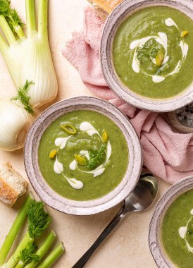 Üç tabak kremalı sebze rezenesi, pırasa ve ıspanak çorbası, vegan kreması ile süslenmiş. Sıcak yemek. Üst görünüm.