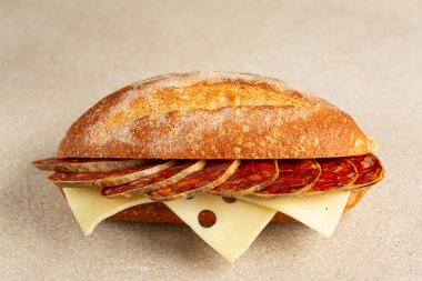 Dilimlenmiş İber sucuklu sandviç, bir sosis, İber domuzu ve kırmızı biberli salam, emmental peynir. Bej arkaplan.