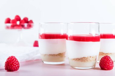 Şanti beyaz çikolata mousse, ahududu püresi jöle ve Badem Çerezler, açık renkli bir temel olarak gelen ahududu tatlı