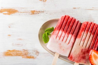 Çilek suyu ve Hindistan cevizi sütü hafif ahşap zemin üzerine ev yapımı Vegan çilekli dondurma. Yaz gıda kavramı. Üstten Görünüm.