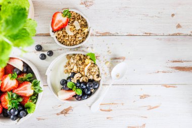 Granola ve ahşap arka plan, üstten görünüm üzerinde taze çilek ile doğal yoğurt kase