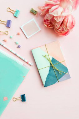 Farklı kırtasiyeli Rüya ve Fikirler ve Pembe arka planda yatan Büyük Pembe Şakayık çiçeklerini yazmak için Boş Not Defteri. Üst Manzara. Kız Ofisi ayarları fikri. Düzleştirme biçimi.