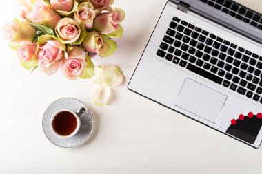 Kadınsı iş mockup dizüstü bilgisayar, gül buketi ve kahve, flatlay boşaltmak Beyaz ahşap zemin üzerine