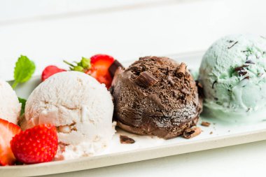 Seçimi farklı dondurma kaşık toz nane, çikolata ve çilek oval tabak gibi