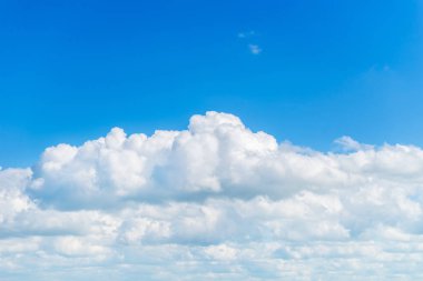 Parlak mavi gökyüzü üzerinde şaşırtıcı beyaz kabarık bulutlar