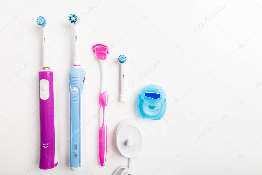 Electric Rechargeable Toothbrushes, Tongue Cleaner and other dental accessories on light background