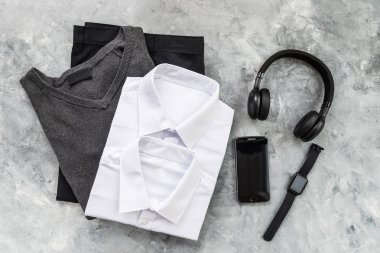 Geri okul kavramı, beyaz gömlek ve pantolon gibi okul üniforması, hem de akıllı izle, telefon gibi elektronik cihazlar ve açık renkli kulaklıklar için
