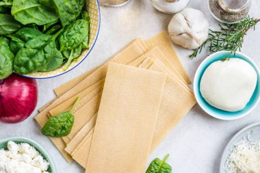 Vejetaryen ıspanak ve Ricotta lazanya, üstten görünüm, gri arka plan için malzemeler 