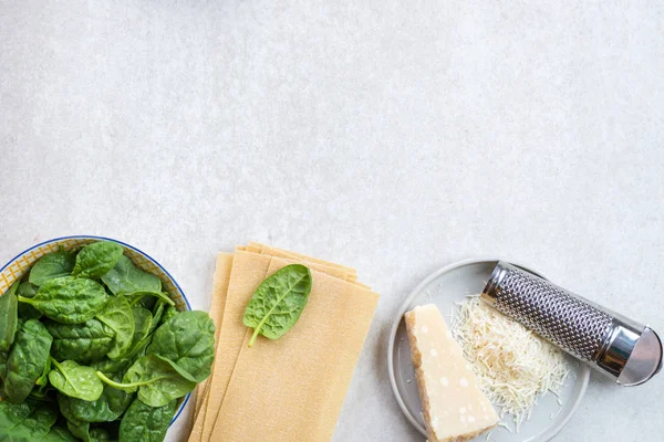 Vejetaryen ıspanak ve Ricotta lazanya, üstten görünüm, gri arka plan için malzemeler 