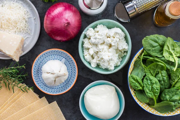 Vejetaryen ıspanak ve Ricotta lazanya, üstten görünüm, koyu arka plan için malzemeler 