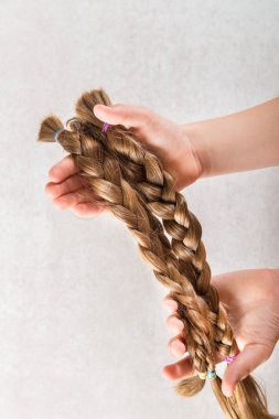 Elini uzun saç peruk kanser hastaları için açık renkli yapar çocuklara yardım için bağış olarak tutuyor