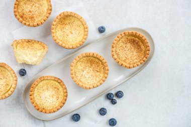 Ücretsiz aralığı yumurta kremalı Tart, gri arka plan üzerinde geleneksel İngilizce, Portekizce, Çince tatlı