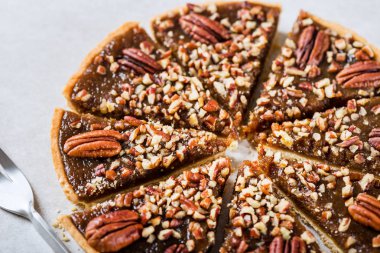 Cevizli turta, zenginleştirilmiş tereyağı pasta altın şurup, akçaağaç sos ve ekmek kırıntıları, pecans gri arka plan üzerinde ile tepesinde ile yapılan