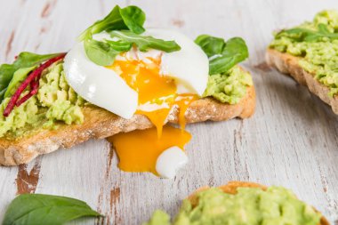 Sağlıklı Kahvaltı ekmek tost ve yeşil salata ve ezilmiş avokado ile haşlanmış yumurta ile