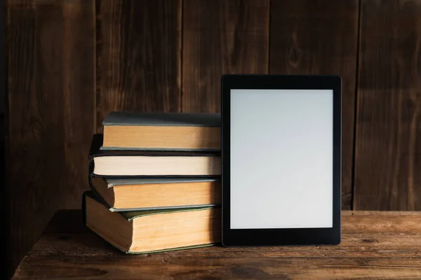 Libro electrónico, dispositivo de tableta digital, con viejos libros reales cerca — Foto de Stock