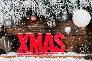 Noel çerçevelemek--dan karlı kürk ağaç dalları, ahşap Xmas harf ve rustik arka plan cam topları