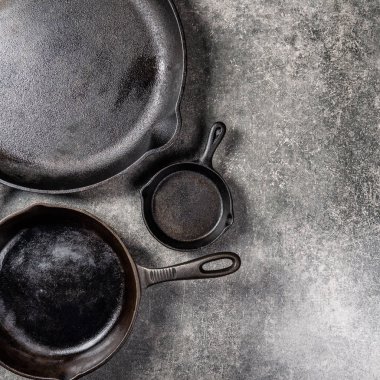 Birkaç dökme demir tava veya Skillets gri arka plan üzerinde sağlıklı yemek pişirmek için