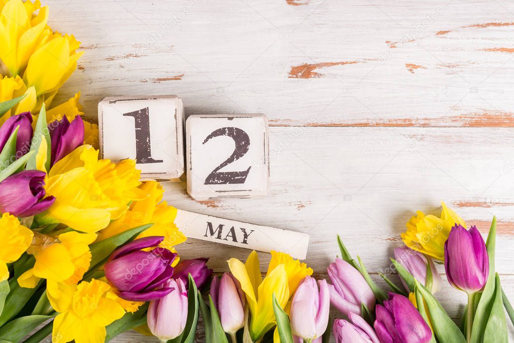 Wooden Blocks with USA Mothers Day Date, 12 May, for the year 2019, Tulips and Narcissus Flowers nearby