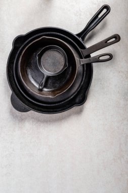 Birkaç dökme demir tava veya Skillets gri arka plan üzerinde sağlıklı yemek pişirmek için