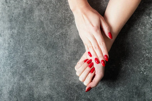 Joven dama está mostrando sus uñas de manicura roja — Foto de Stock