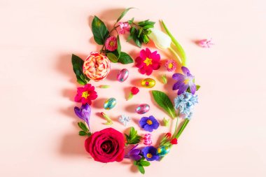 Paskalya en az kavramı. Bahar çiçekleri pembe arka plan üzerinde yapılan yumurta şekli