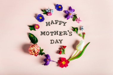 Mutlu anneler günü harfleri ile çevrelerindeki farklı bahar çiçekleri