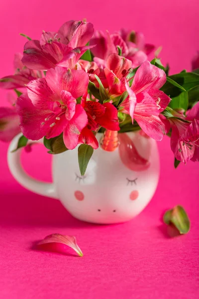 Canecas de unicórnio com Alstroemeria sobre fundo rosa brilhante — Fotografia de Stock