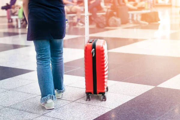 Lány van a repülőtéren, világos és stílusos kabin méretű bőrönde, mint üdülési koncepció — Stock Fotó