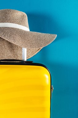 Parlak ve şık kabin büyüklüğünde hasır şapkalı bavul.